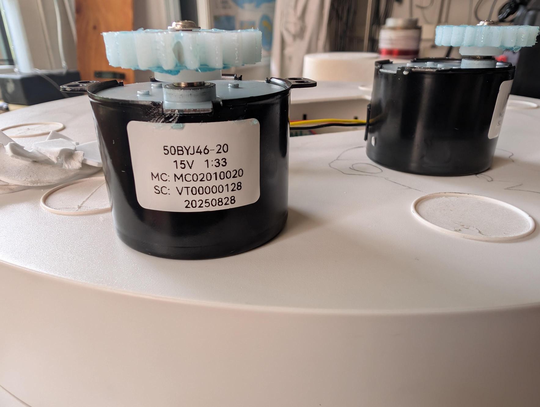 June 23: Front motor label reads: 50BYJ46-20 / 15V 1:33 / MC: MC02010020 / SC: VT00000128 / 20250828. Bipolar stepper, 15V, 1:33 internal planetary gear reduction.